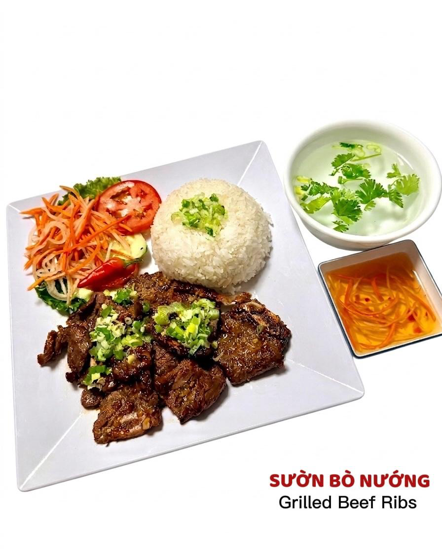 A plate of grilled beef ribs served with white rice, fresh salad, side of soup, and dipping sauce.