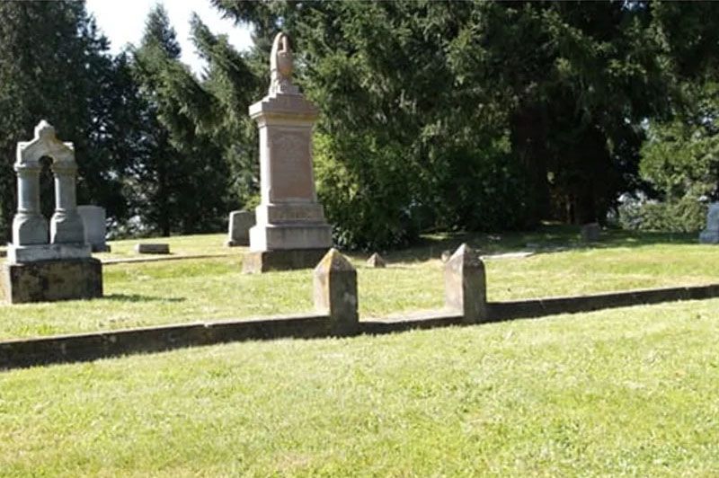 A cemetery with many graves and trees in the background