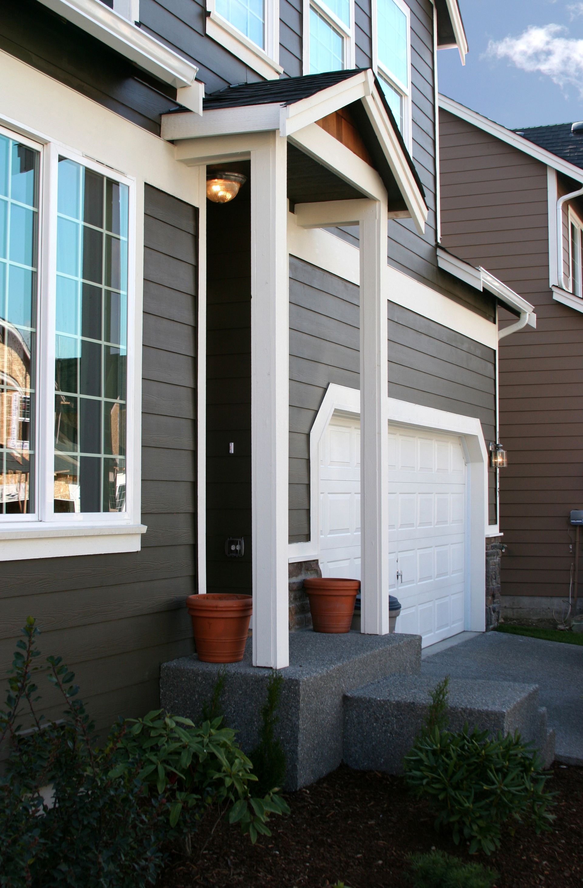 A house with a porch and a white garage door