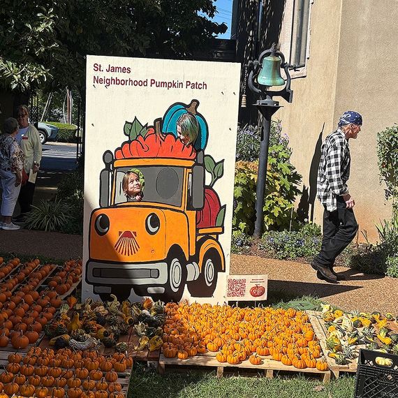 Pumpkin patch with an orange truck cutout, pumpkins, and a person walking by.