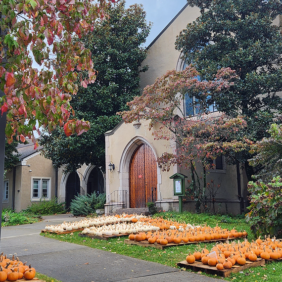 Church entrance with pumpkins for sale in autumn.