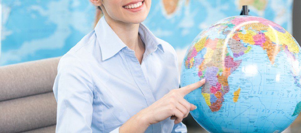 woman pointing a place on a globe