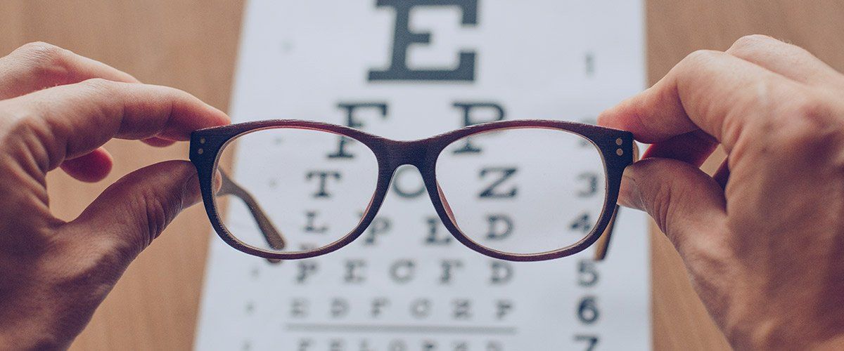 occhiali davanti a tabella optometrica