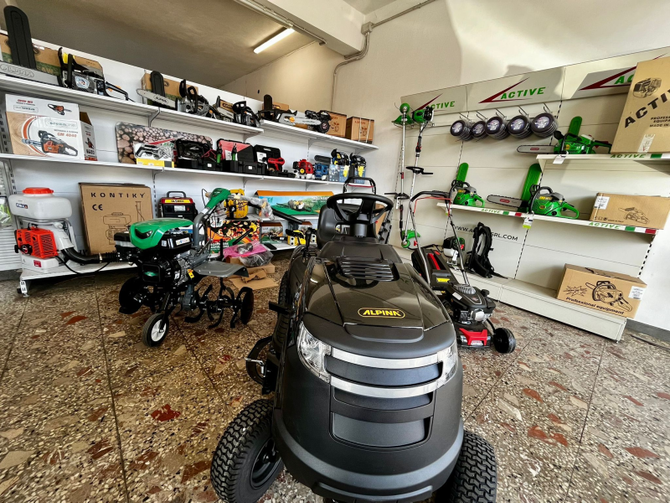 Showroom di tosaerba con vari attrezzi da giardinaggio esposti sugli scaffali.