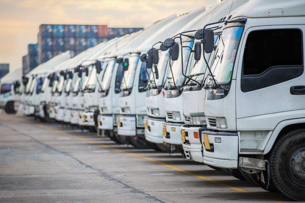 A Row of White Trucks Are Parked Outside — JEC Transport in Winnellie, NT