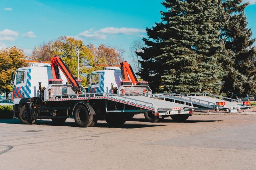 Two Tow Trucks Are Parked Next to Each Other in a Parking Lot — JEC Transport in Winnellie, NT