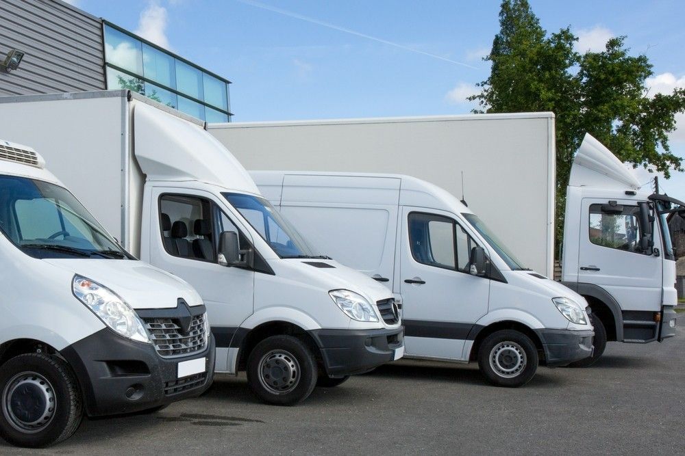 Three White Vans Are Parked Next to Each Other in a Parking Lot — JEC Transport in Winnellie, NT