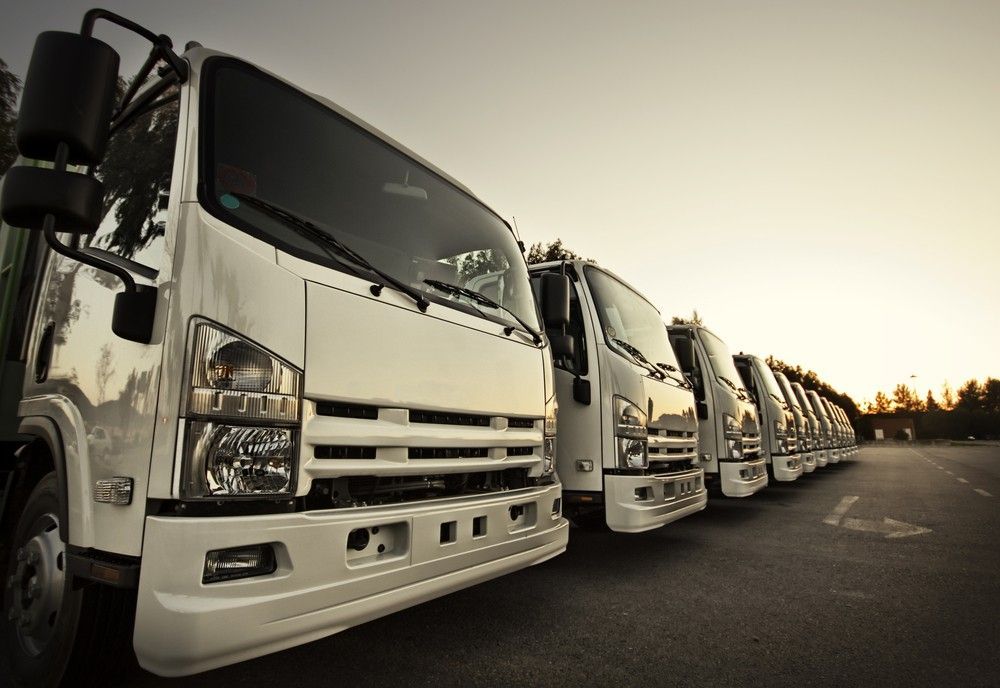 A Row of White Trucks Are Parked in a Parking Lot — JEC Transport in Palmerston, NT