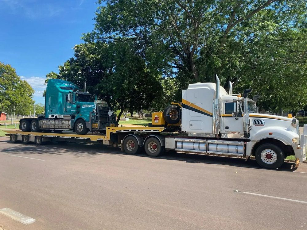 Two Semi Trucks Are Parked Next to Each Other on the Side of the Road — JEC Transport in Winnellie, NT