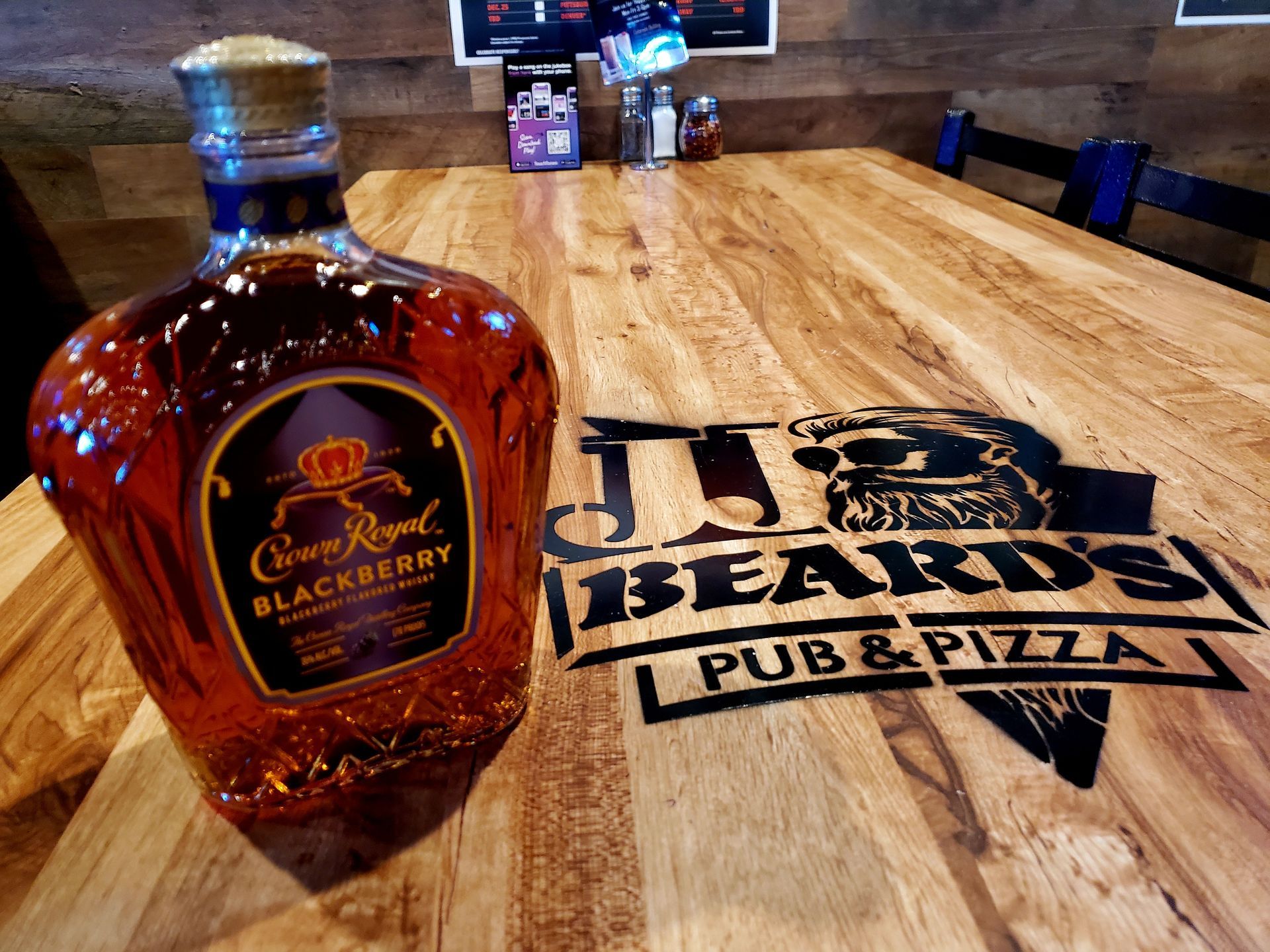 A bottle of crown royal blackberry on a wooden table