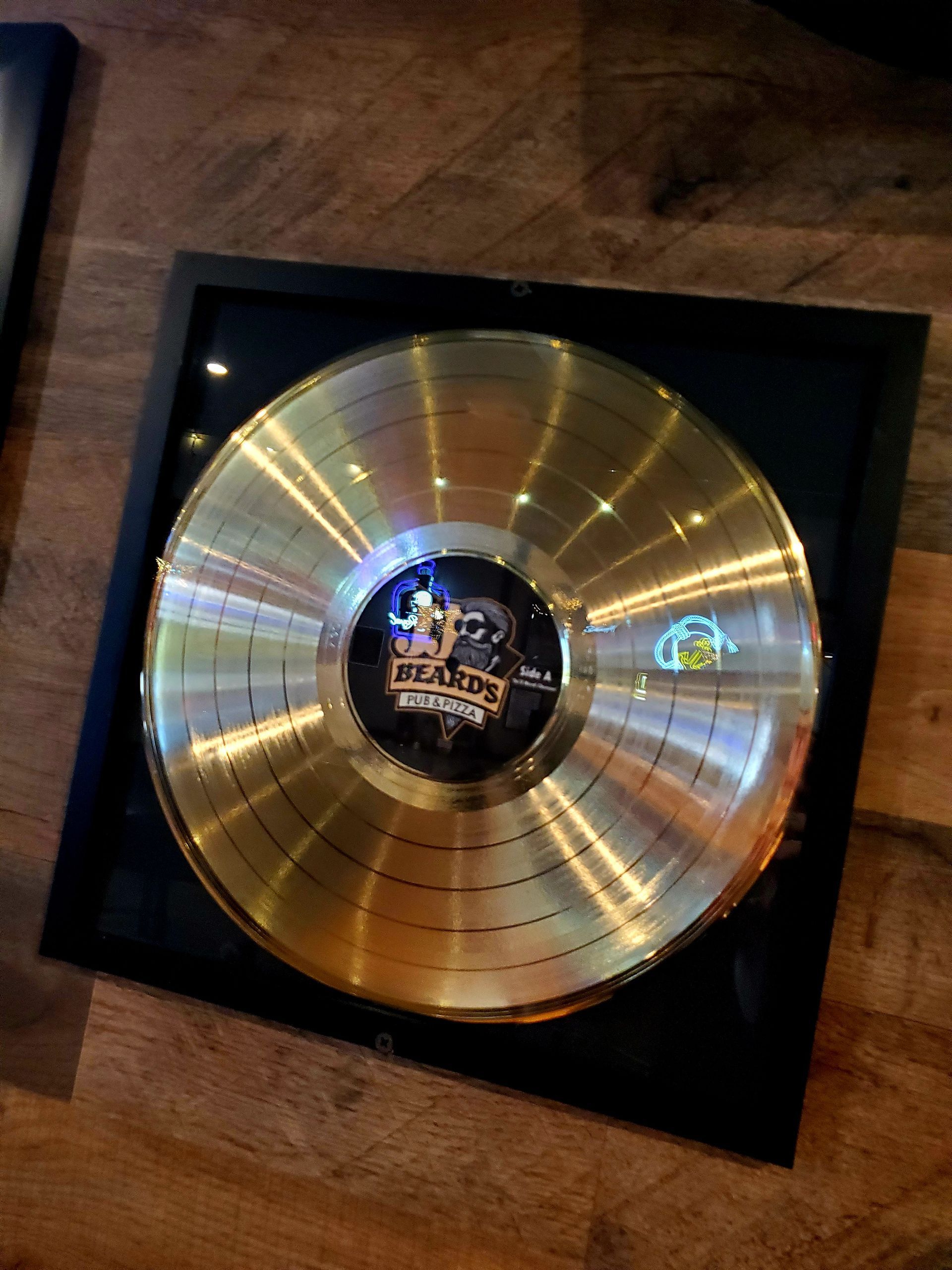 A gold record is sitting on a wooden table