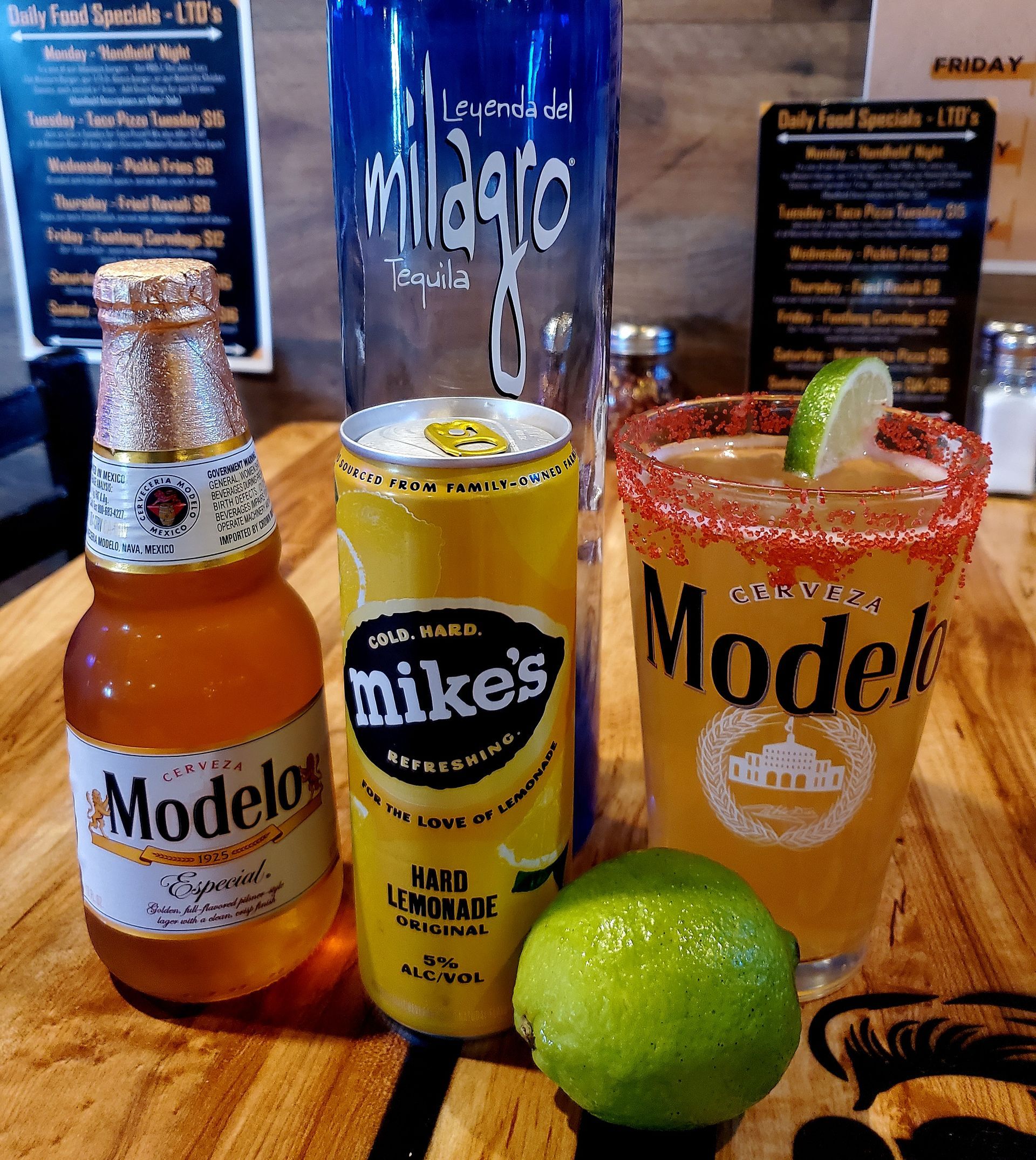 A bottle of mike 's beer sits next to a can of modelo beer