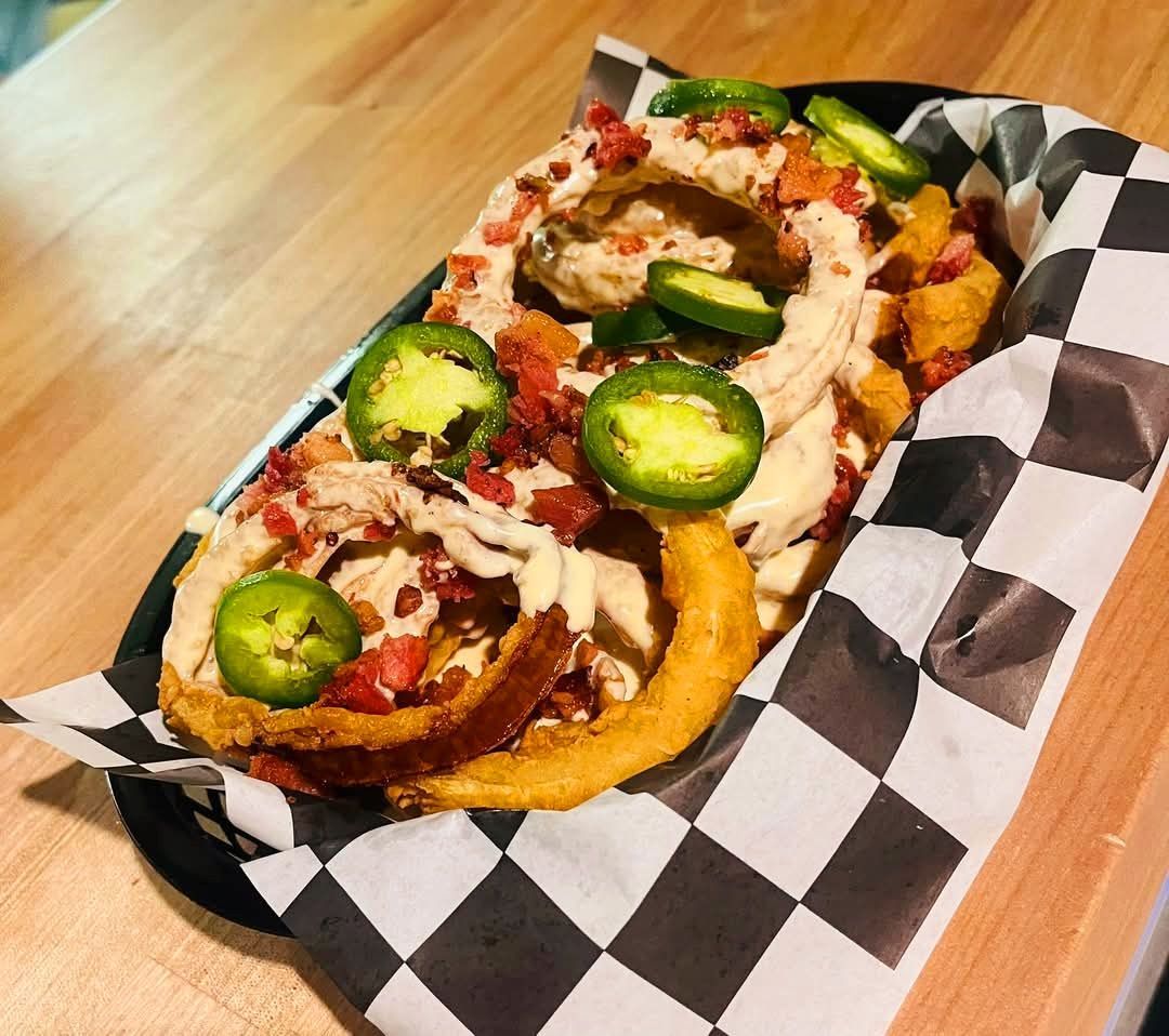 A close up of a plate of food on a checkered paper on a table.