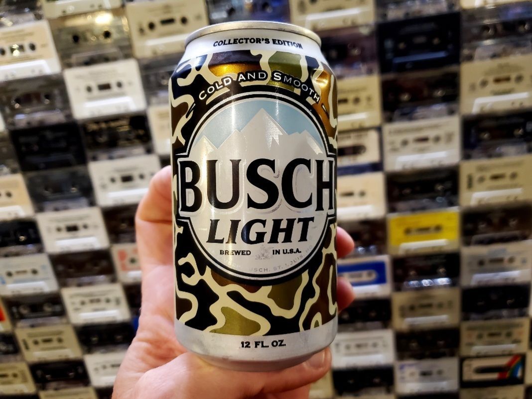 A person is holding a can of busch light beer