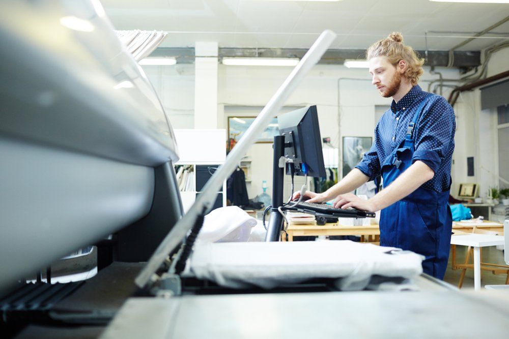 A man is working on a computer in a factory.