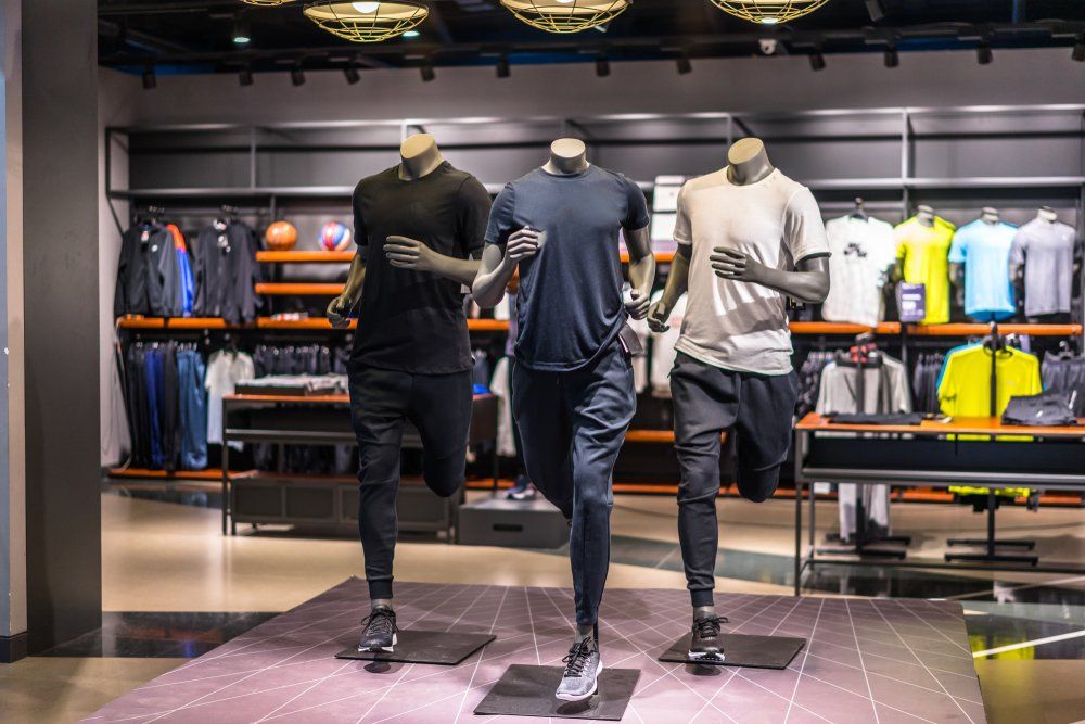 Three mannequins are running in a nike store.