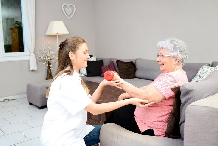 Home Healthcare Worker Using Weights With Patient