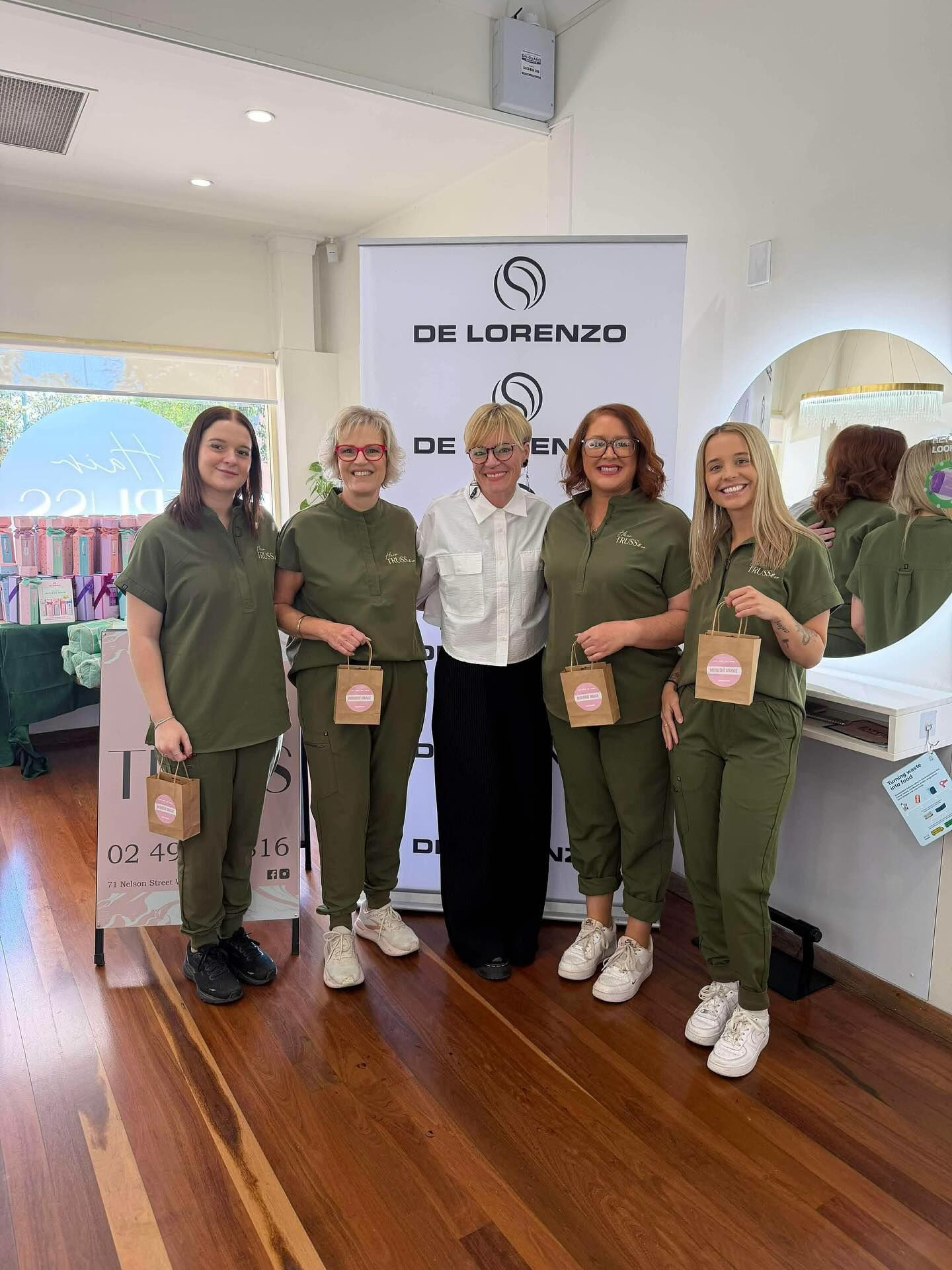 Group Posing Indoors Around a White Cake, With a Woman — Hair Truss & Co In Wallsend, NSW