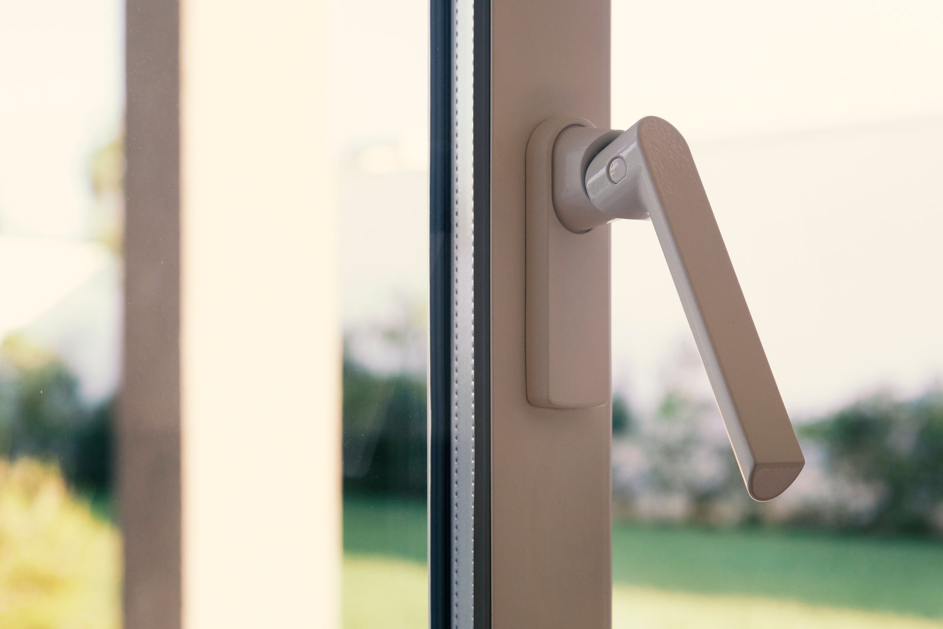 Closeup to the white handle of a double-glazed window or door.