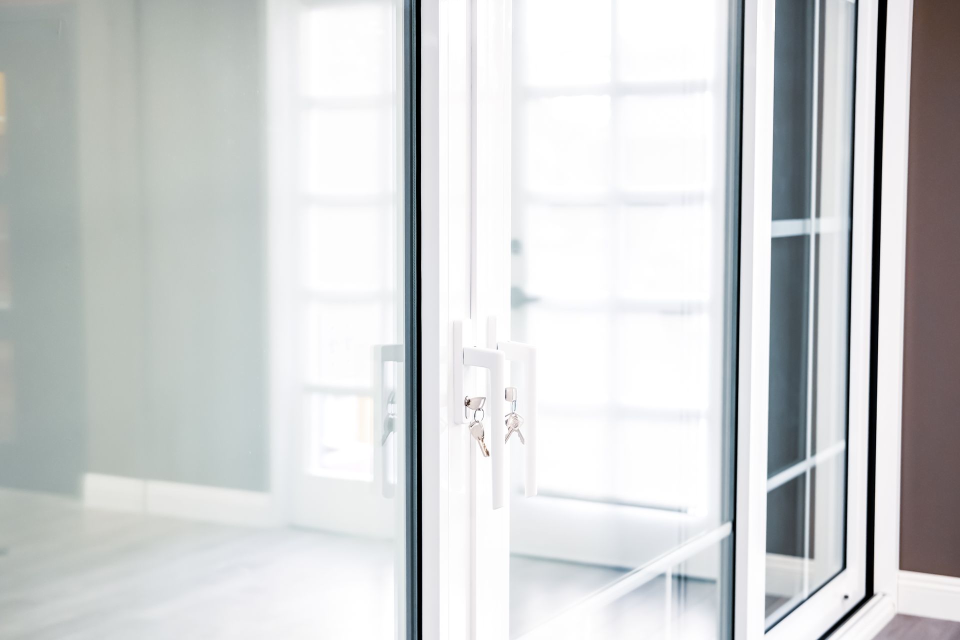 Modern PVC doors reflecting windows nearby.