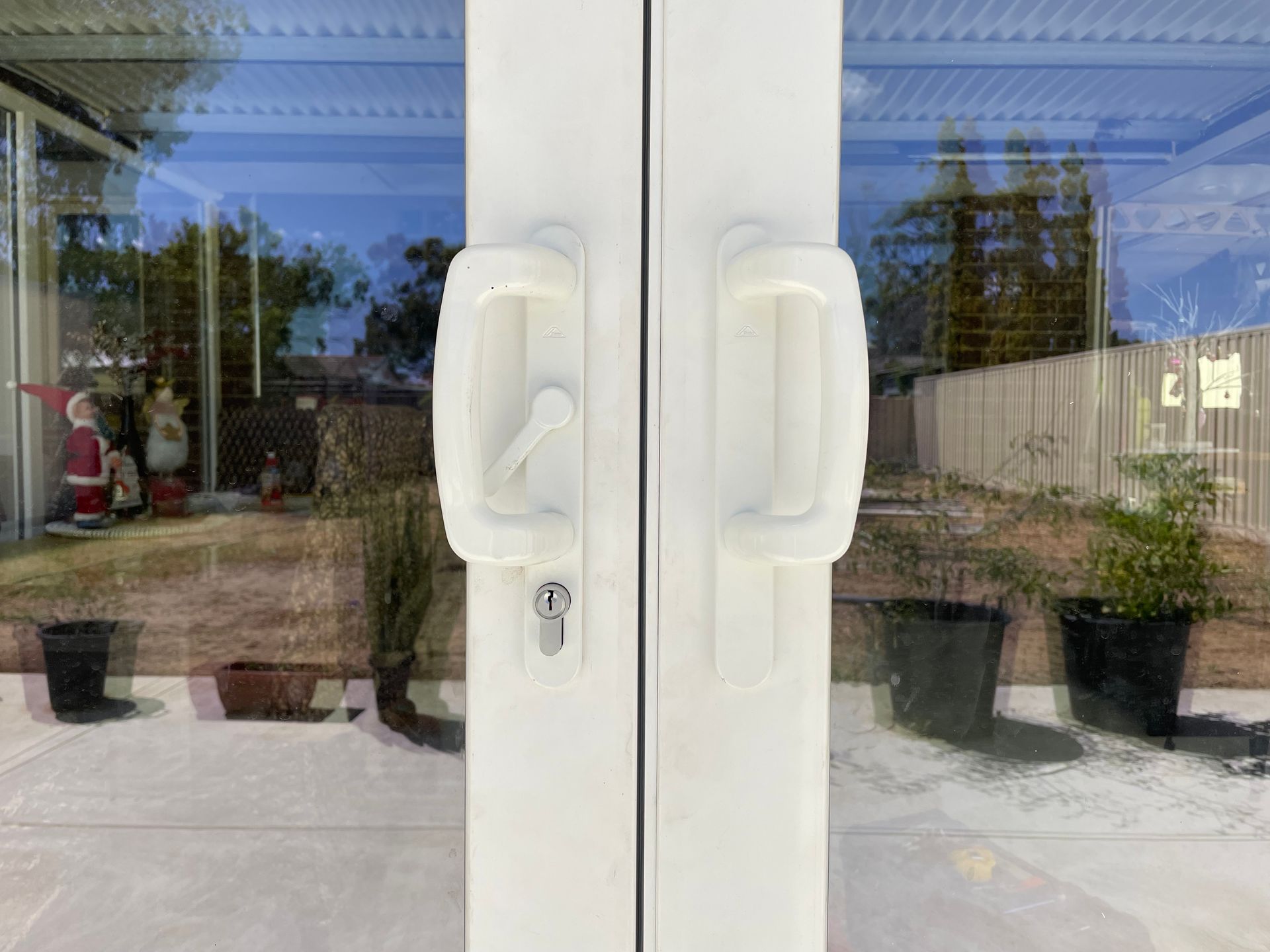 Closeup to the white handle of a double-glazed window or door.