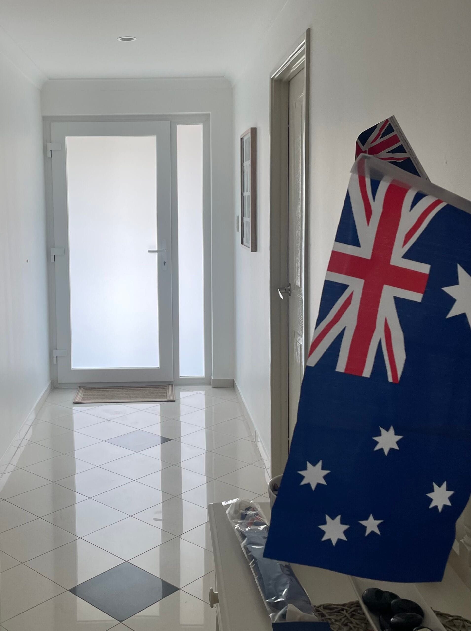 Hallway with an Australian flag in the foreground and a frosted glass door at the end.