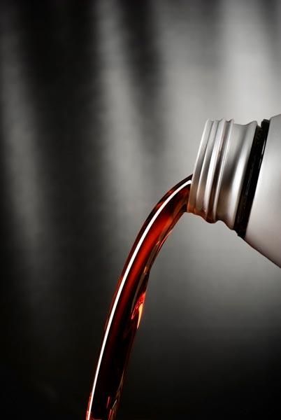 Se vierte una botella de líquido rojo en un vaso