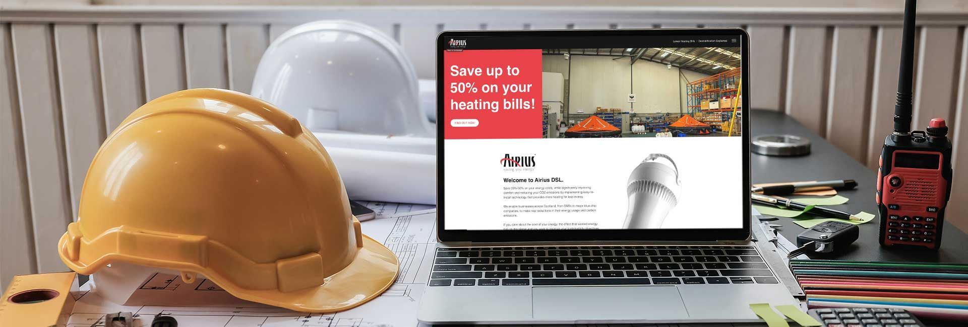a hard hat sits next to a laptop that says save up to 50 % on your heating bills