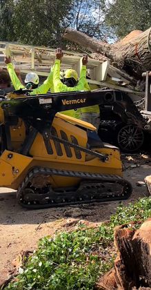 A group of people are standing next to a yellow bulldozer.