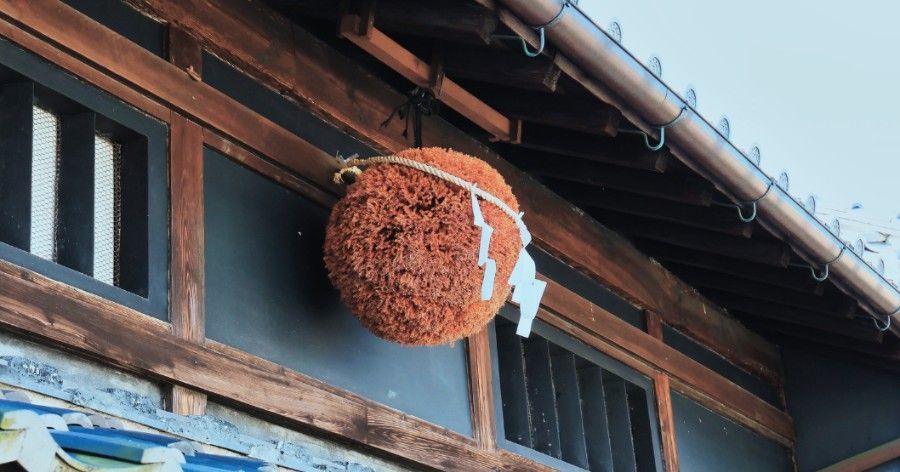 A brown sugidama (cedar ball) hangs outside a Japanese building.