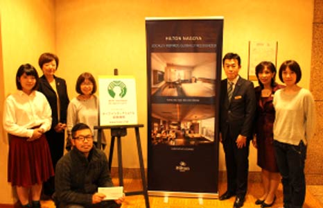 A group of people are posing for a picture in front of a sign.