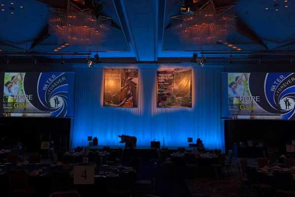 A large room with a stage and a lot of tables and chairs.