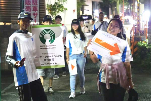 A group of people are walking down a street holding signs.