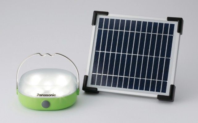 Small white-and-green Panasonic portable lantern beside a compact solar panel