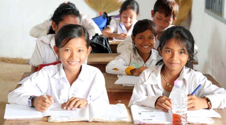 A group of children are sitting at desks in a classroom.
