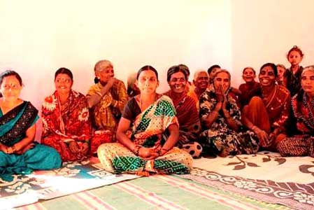 A group of women are sitting on the floor in a room.