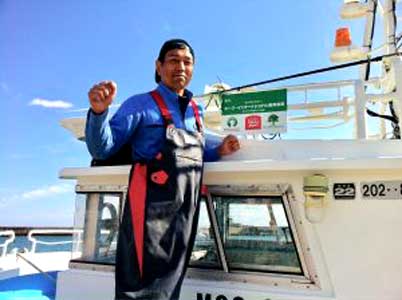 A man is standing on the deck of a boat.