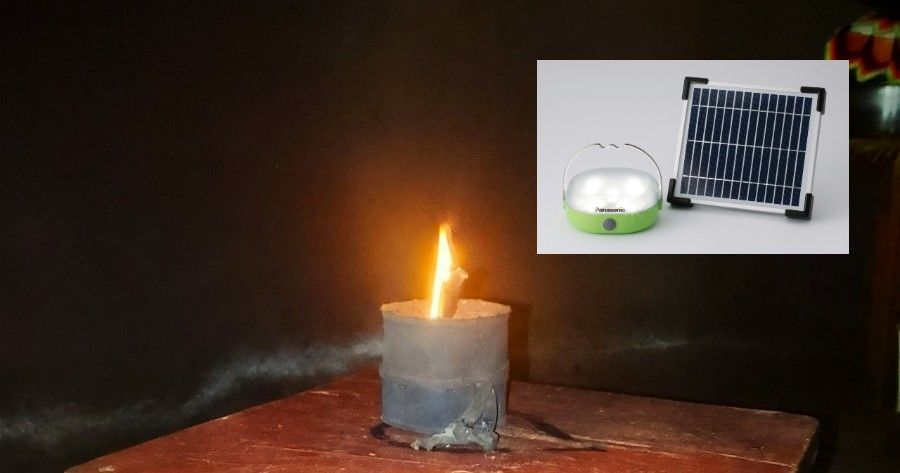 Lit candle on a table with smoke, and a small inset showing a solar-powered lamp setup