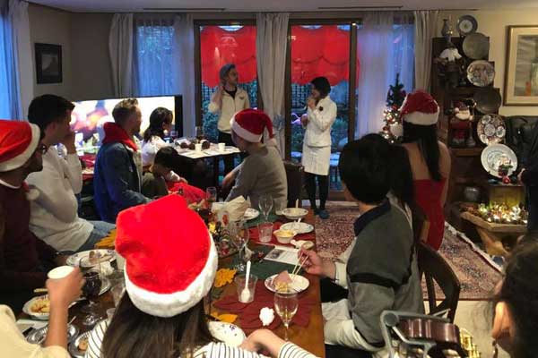A group of people wearing santa hats are sitting at a table.
