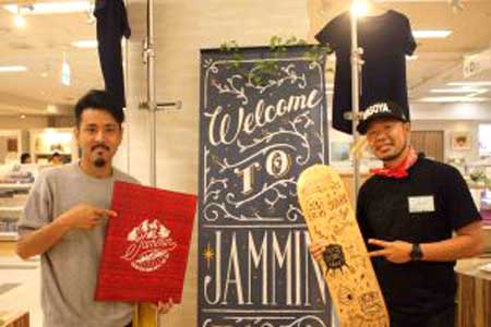 Two men are standing next to each other in front of a sign that says welcome to jammin.