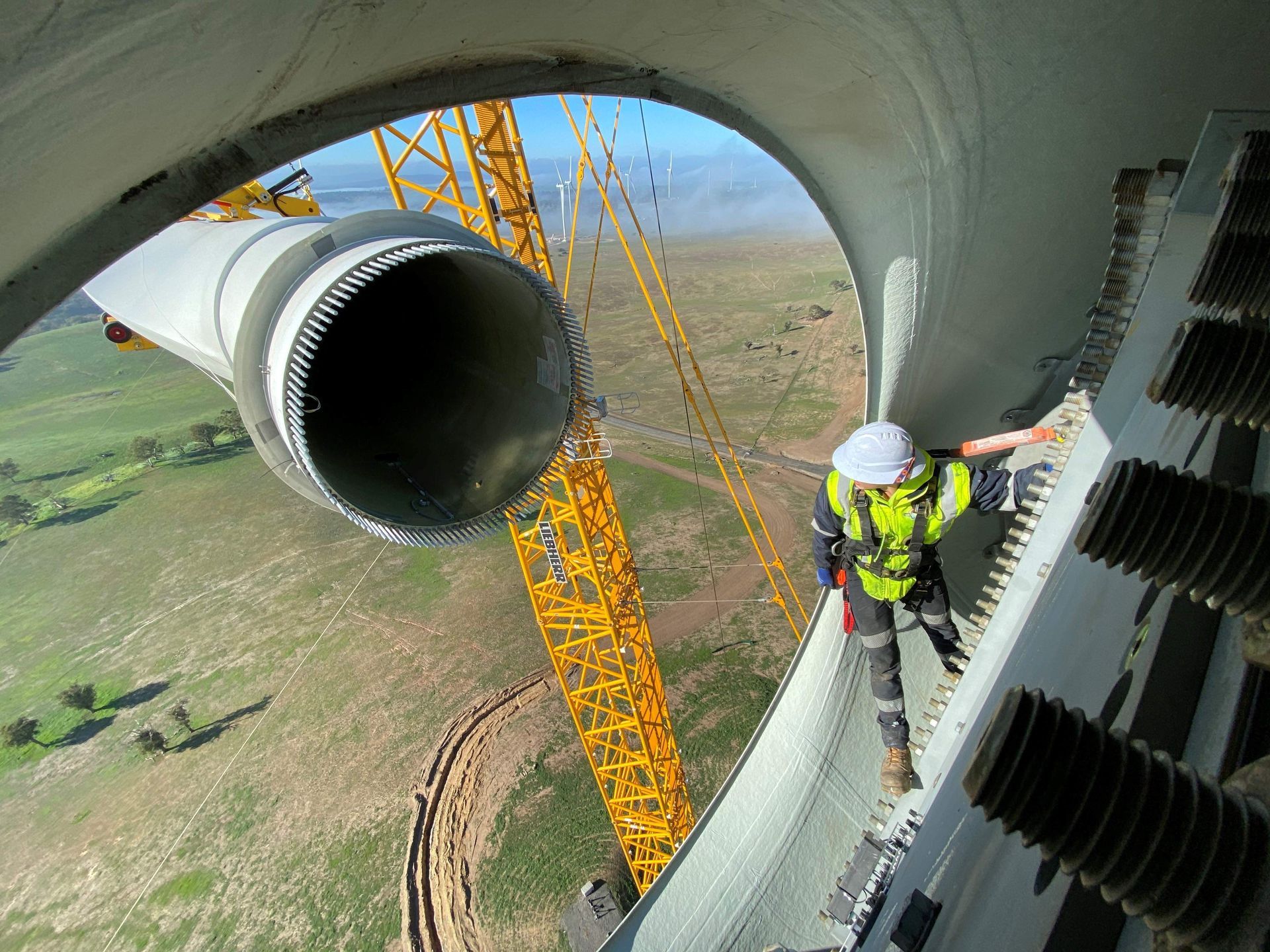 A man is standing on top of a large pipe.