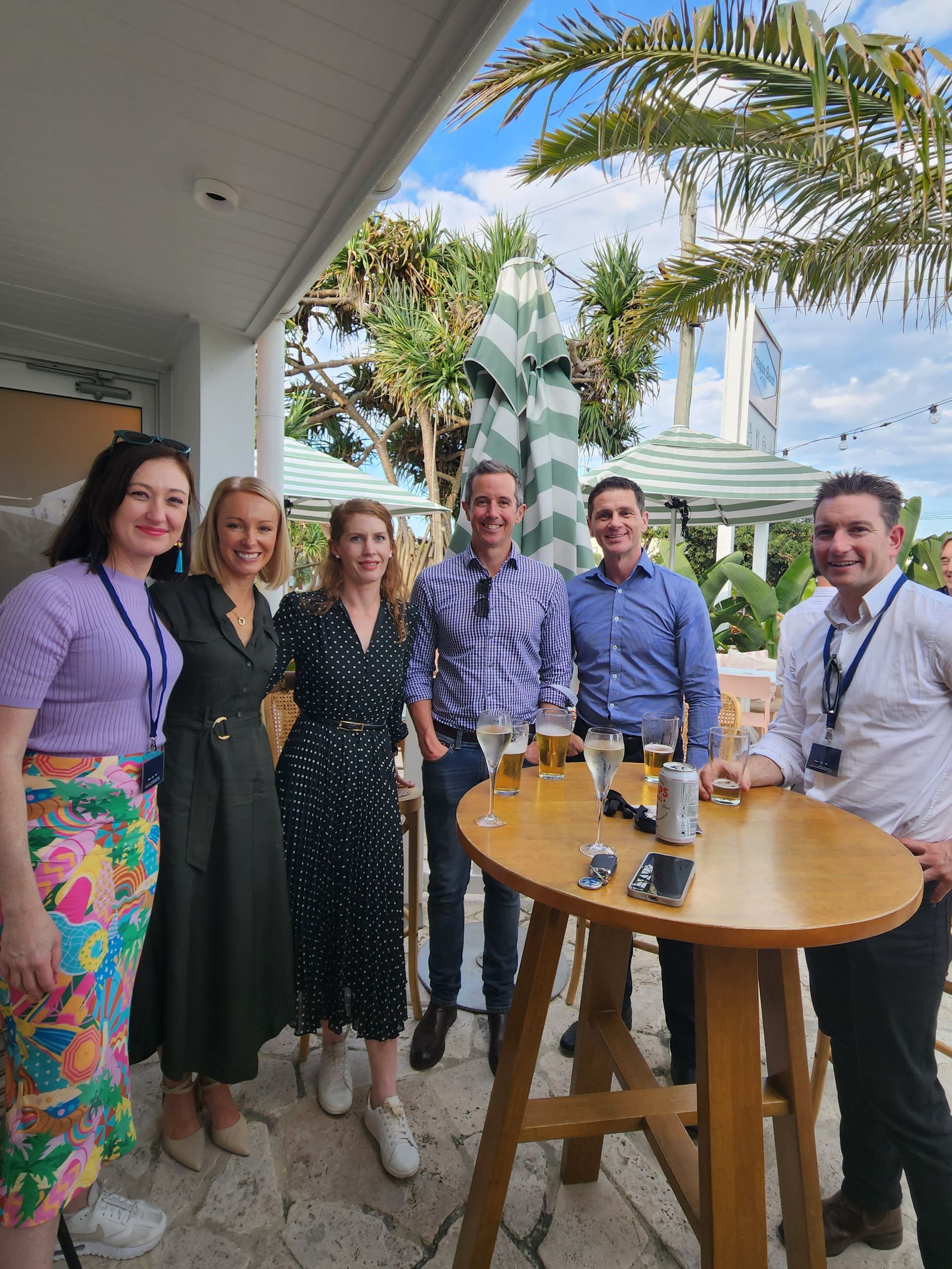 A group of people standing around a table with glasses of beer. LG Innovate AI Summit 2024.