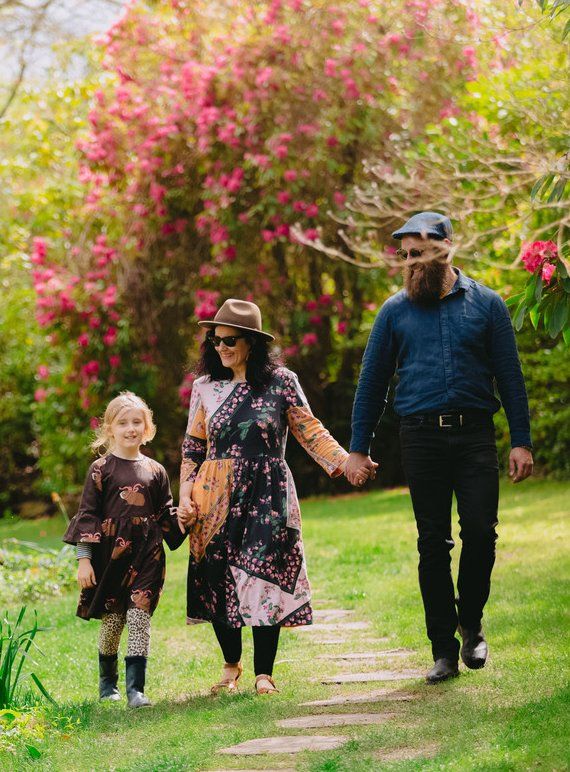 Small family walk through a garden hand in hand