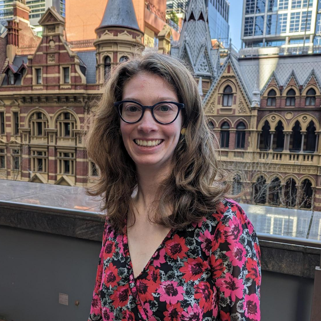 Lily - employee at Davidson's Melbourne office standing with old buildings in the backrgound