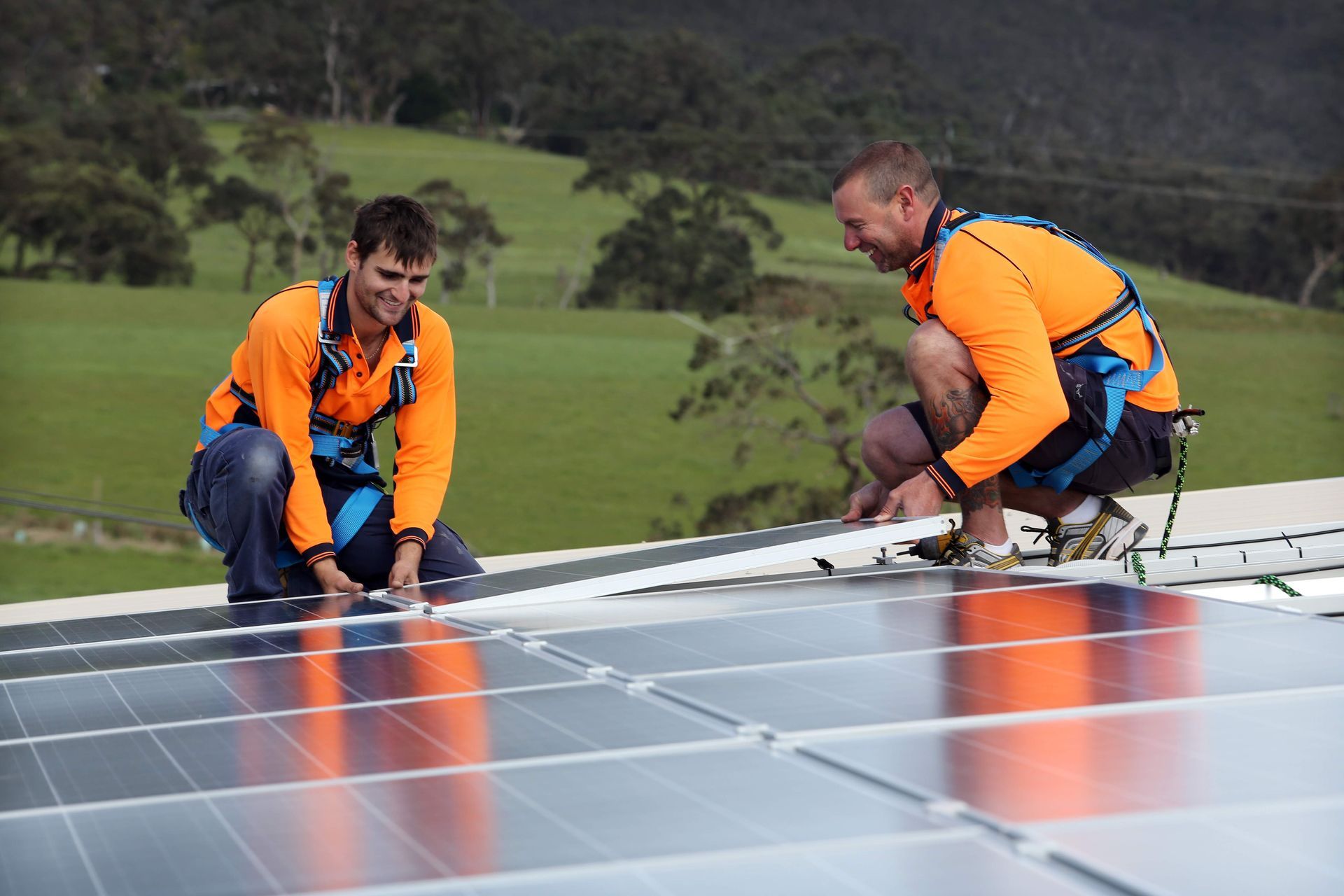 Two men are installing solar panels on a roof.