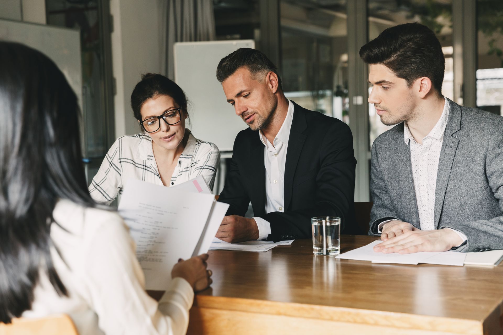 Two men and a woman having a business meeting with a female client