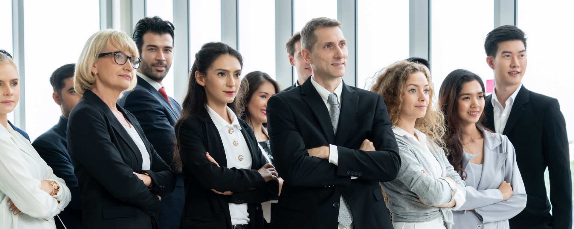 A group of business people are standing in a row with their arms crossed, executive leadership.