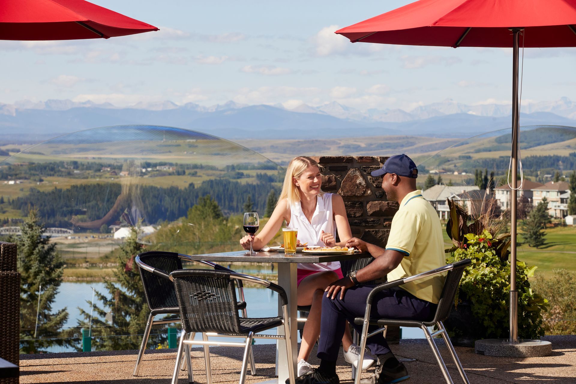 View from a window of a sunset over a snowy landscape, a table, and a chair.