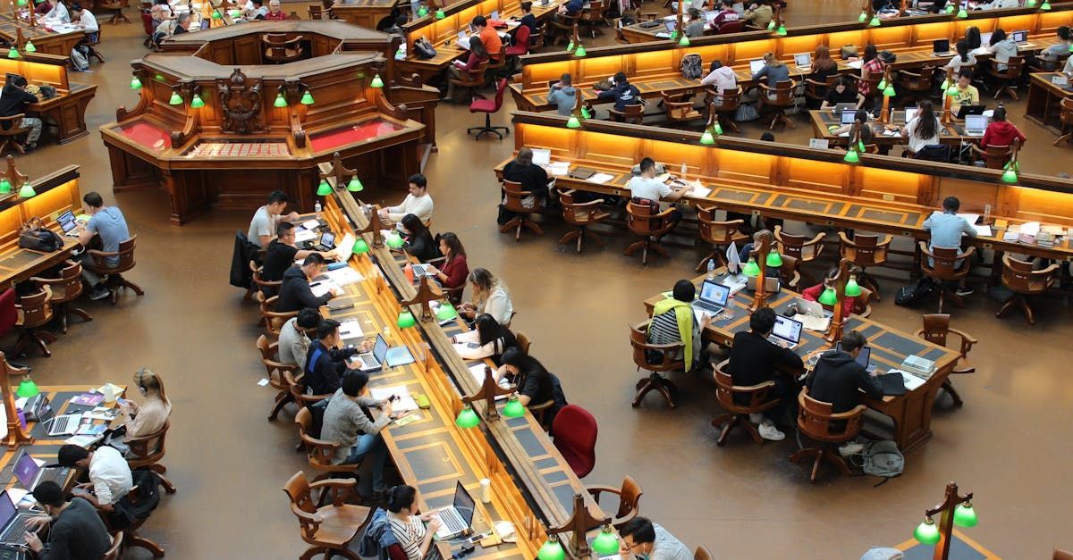 A large group of people are sitting at tables in a library.