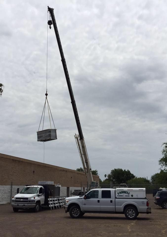 a truck is being lifted by a crane in front of a building .